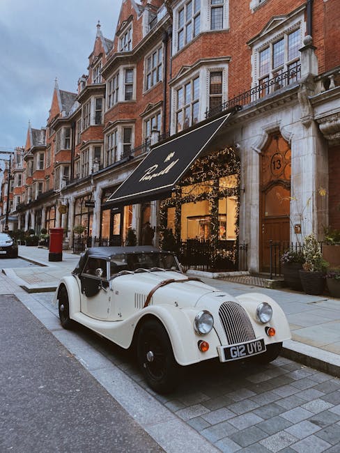 A busy street scene in Mayfair near Bond Street Station featuring a row of multi-storey retail buildings with large display windows, including a Levi's store with 'SALE' signs in the window. The stree