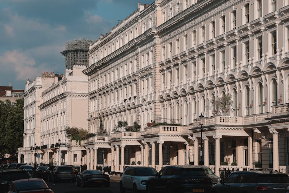 The exterior of a red-brick residential building with multiple small balconies featuring ornate black metal railings is visible. A street sign reading 'Davies Street W1' is attached to the corner of t